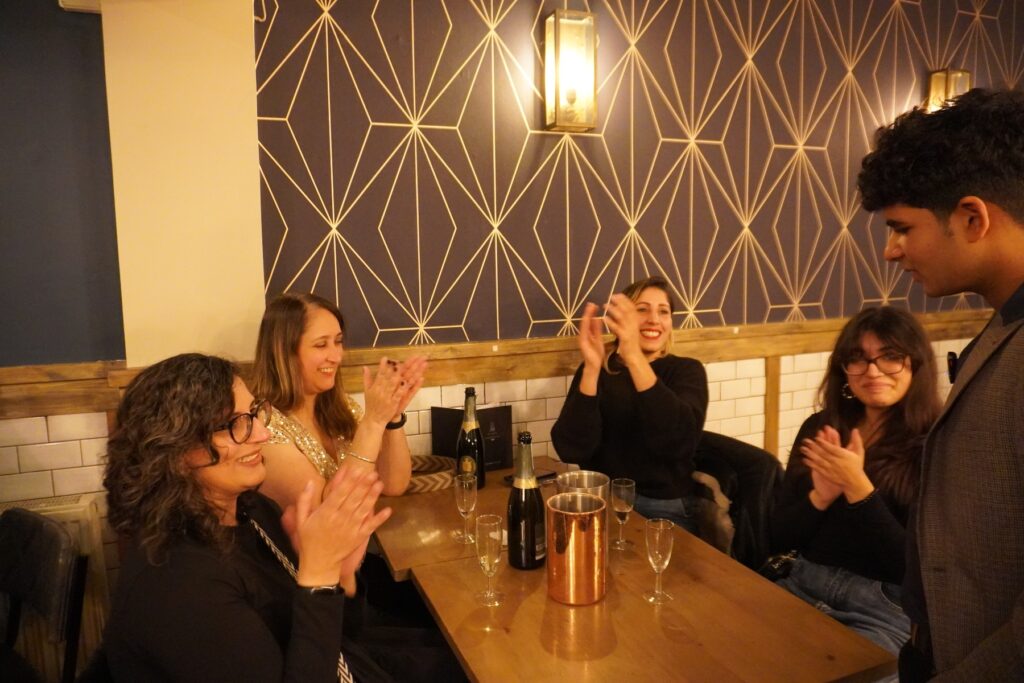Party magician performing close-up magic for guests at a birthday party